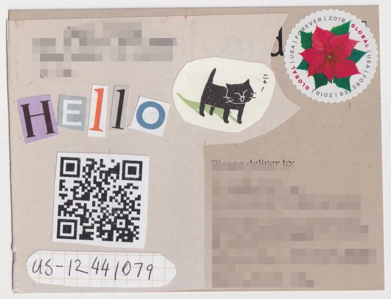 Back of postcard. Address is blurred. Kraft paper colored card has newsprint glued over it with a collage on the top. The collage spells "HELLO" with letters cut out from magazines. There is a QR code on the card leading to a youtube.com rickroll.